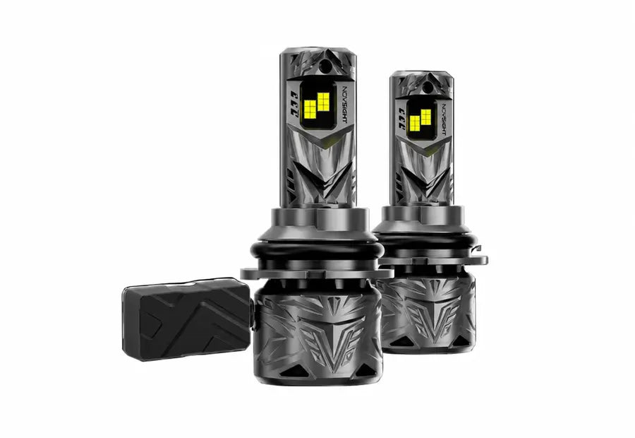 Two black LED car headlights with a textured metallic finish and a separate black mounting piece, shown on a solid white background.