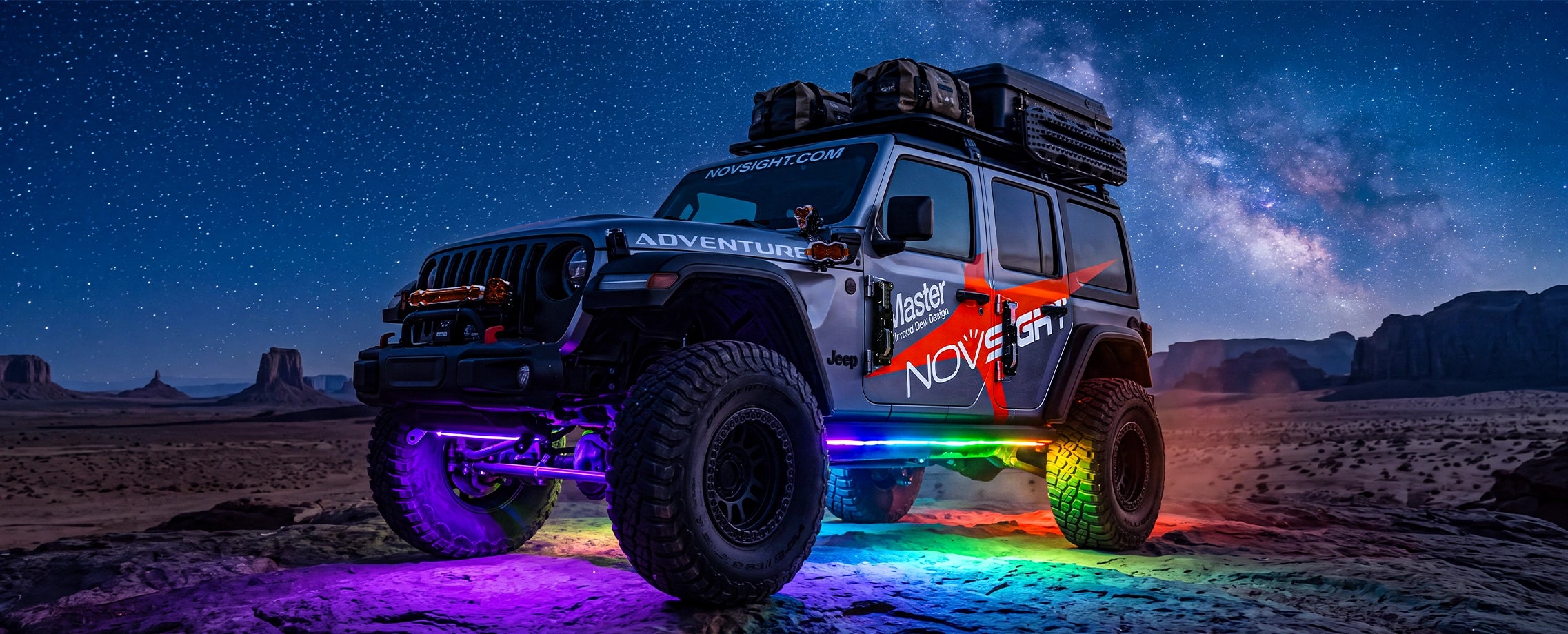 RGB underglow carpet of light under a Jeep Wrangler in the desert at night