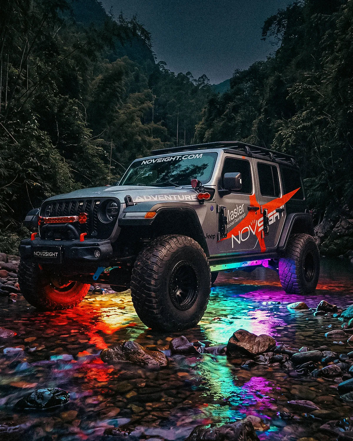 Jeep Wrangler crossing a rocky stream with RGB underglow reflecting off the water